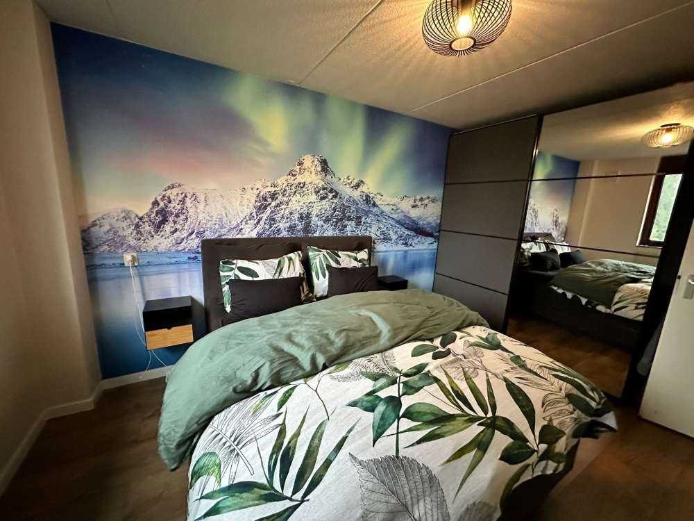 Nordlicht über einem zugefrorenen Ozean und Bergen