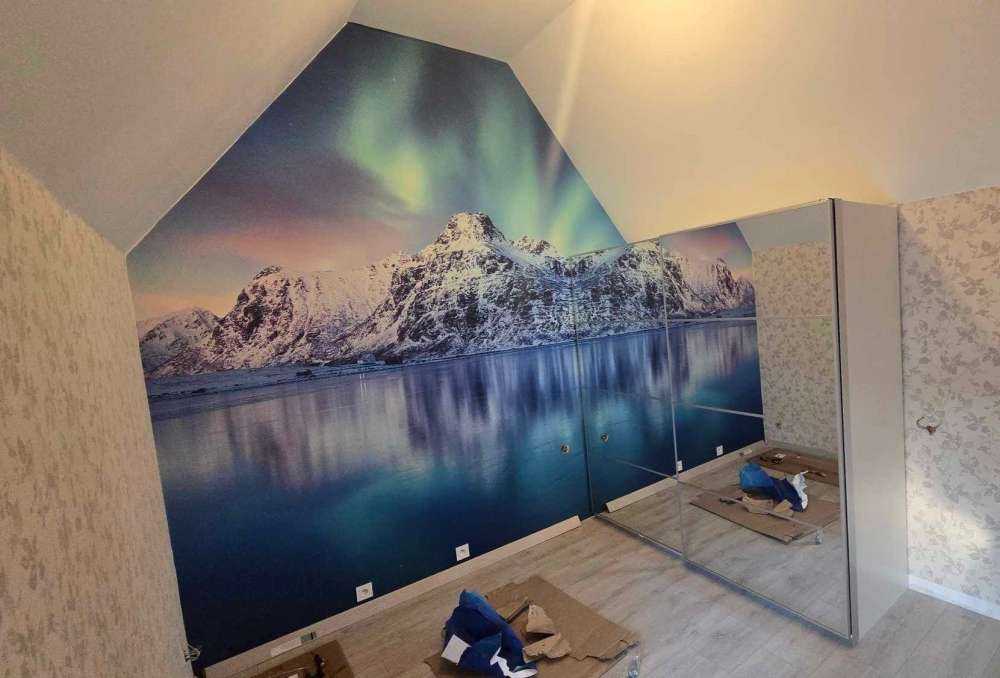 Nordlicht über einem zugefrorenen Ozean und Bergen