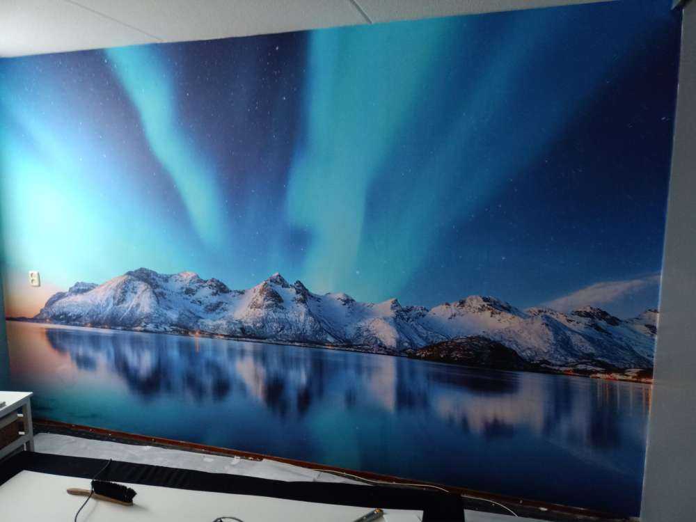 Nordlicht über einem zugefrorenen Ozean und Bergen