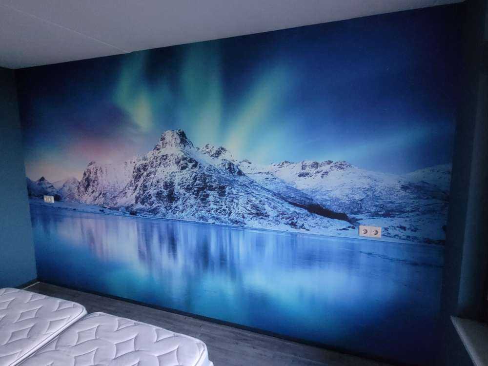 Nordlicht über einem zugefrorenen Ozean und Bergen