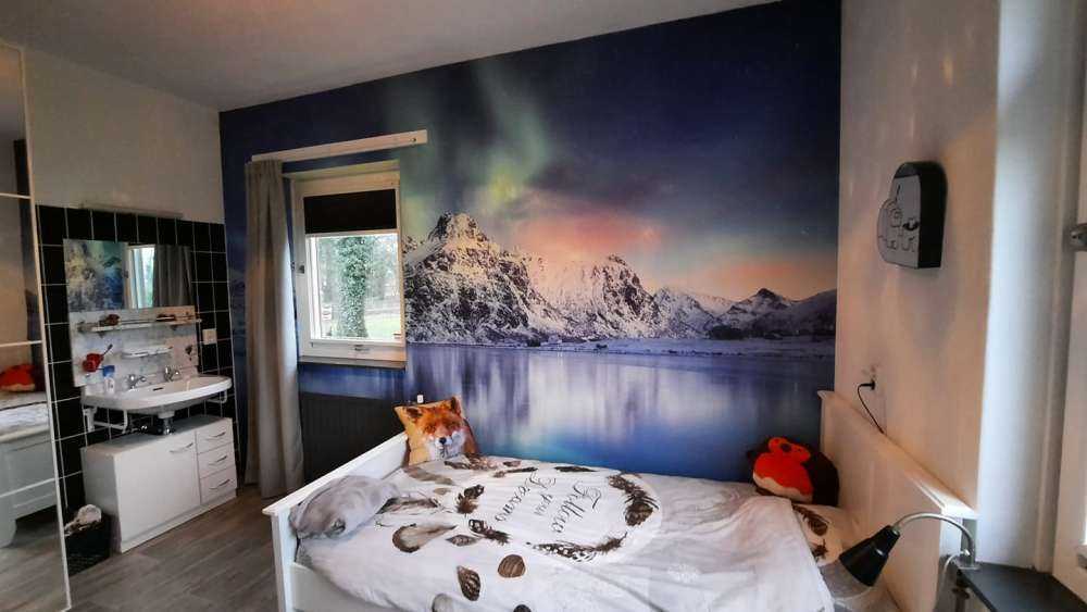 Nordlicht über einem zugefrorenen Ozean und Bergen