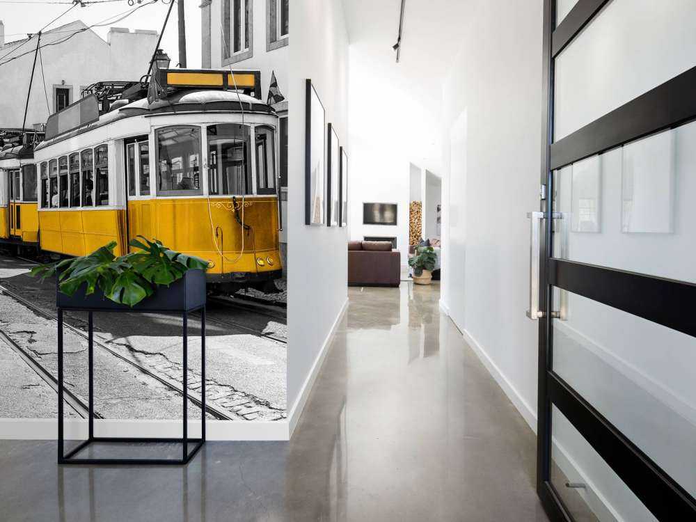 Gelbe Straßenbahn in einer schwarz-weißen Straße