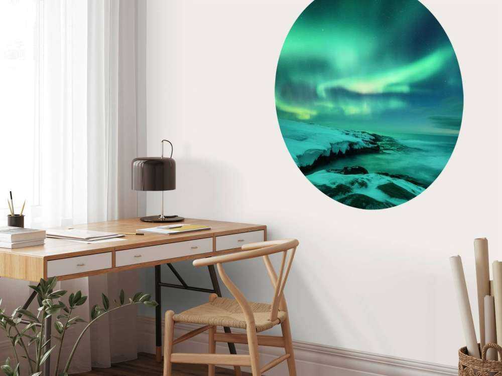 Grünes Nordlicht über verschneiten Felsen
